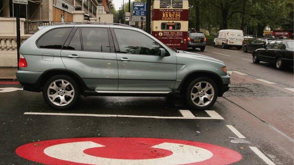 car in street near congestion charge sign