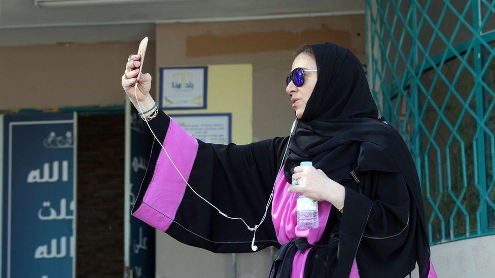 Activist Ghada Ghazzawi records a video on her phone in Jeddah