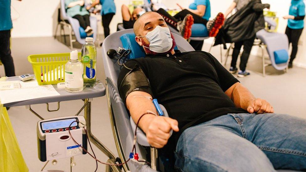 A young man lying in a chair as he donates his blood