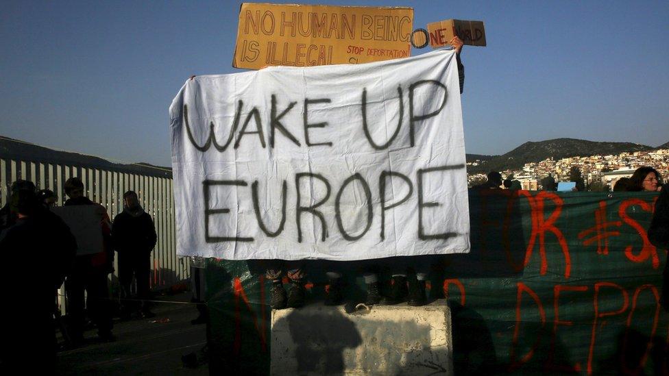 Activists hold banners saying "Wake up Europe" and "No human being is illegal, stop deportation" as they protested against the return of migrants to Turkey in Lesbos