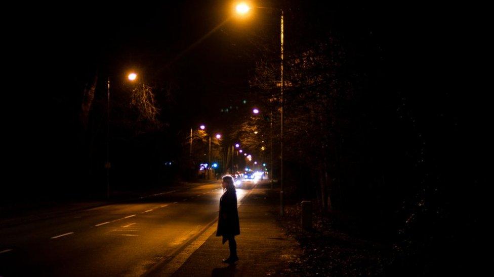 Woman under a street lamp