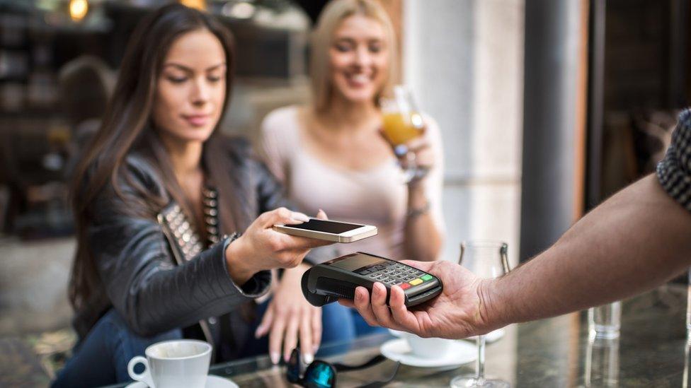 You woman paying with a smartphone