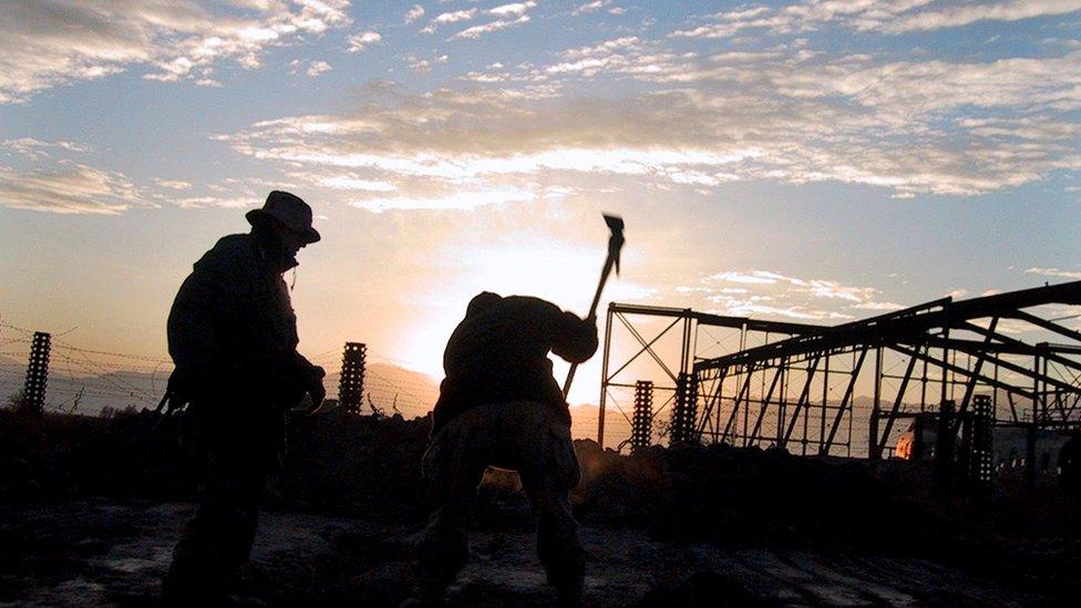 Soldiers from the 10th Mountain Division prepare ground to bury a piece of rubble from the World Trade Center at Bagram Air Field north of Kabul on December 21, 2001