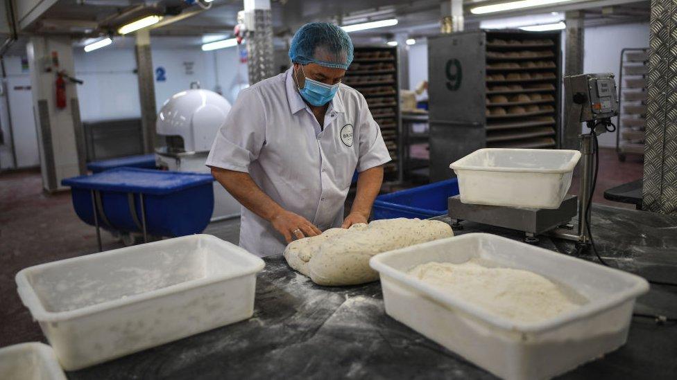 A baker is seen wearing a face mask while working at The Bread Factory on April 14, 2020 in London, England