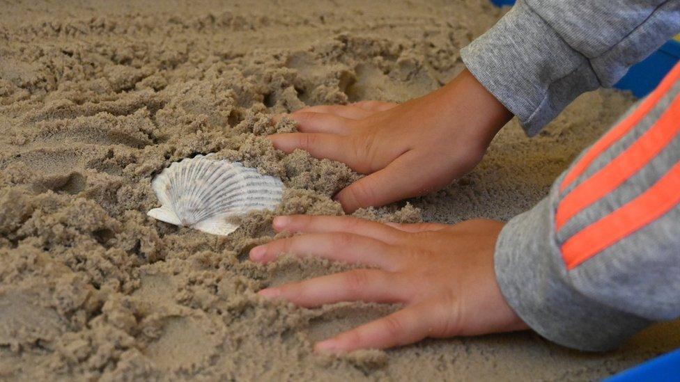 A child plays in a sand pit