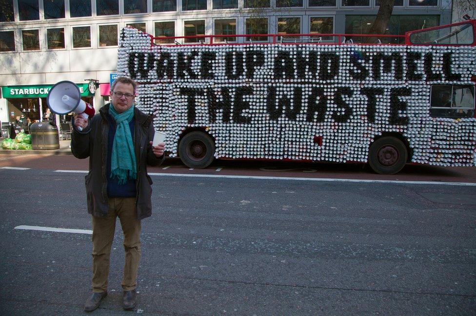 Hugh Fearnley-Whittingstall standing in front of a bus made of cups