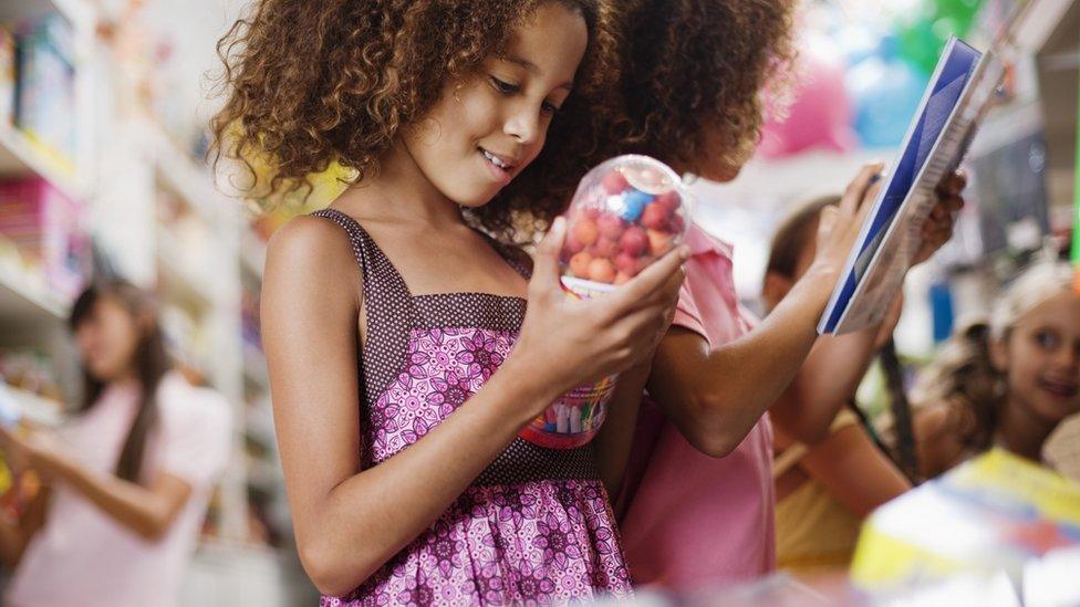 Two girls look at toys in a toy shop