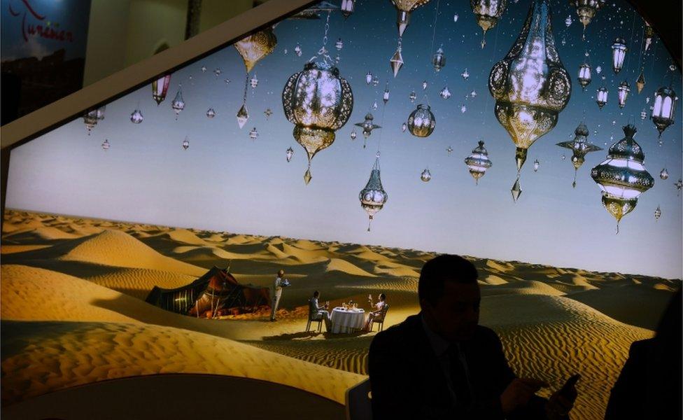 A man uses his mobile phone at the booth of Tunisia at the International Tourism Fair ITB in Berlin on March 10 2016