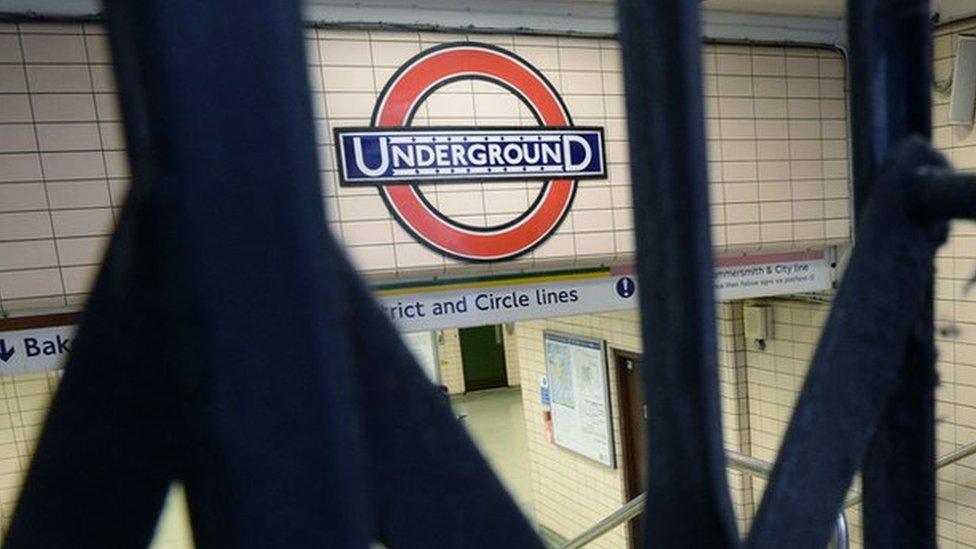 Underground sign seen through closed gates