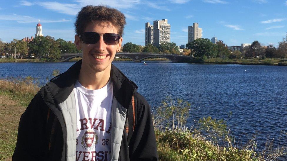 Thomas Burr standing in front of a river at Harvard University