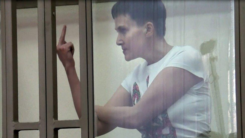 A screen grab taken from an AFP TV video on March 9, 2016 shows Ukrainian military pilot Nadiya Savchenko, accused of involvement in the killing of two Russian journalists in war-torn Ukraine, showing her middle finger