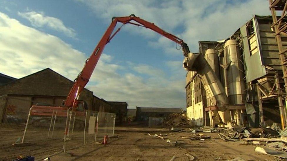 Machine demolishing building