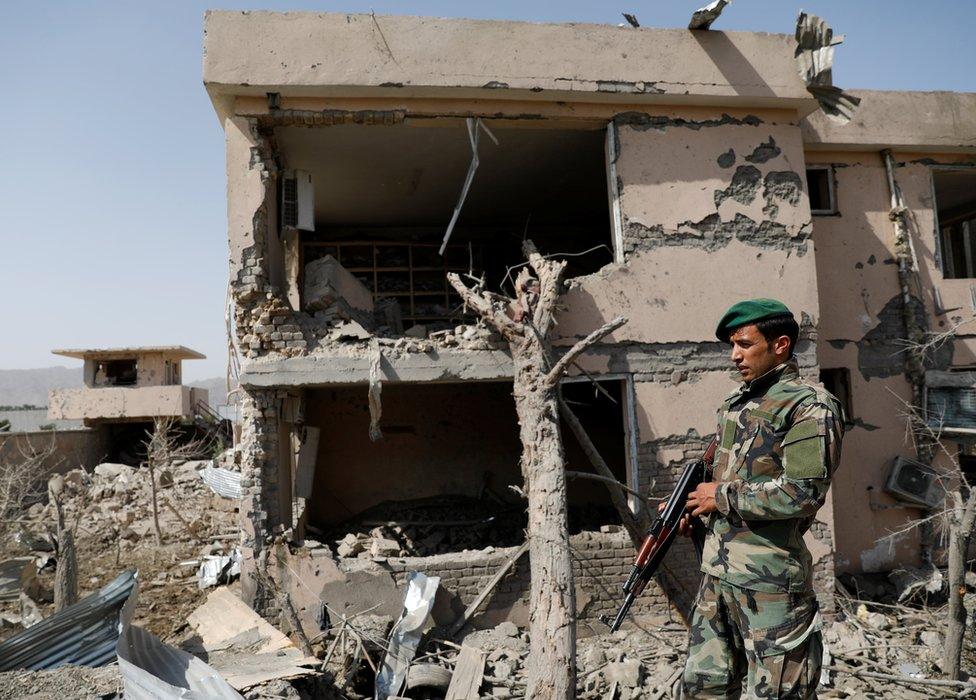 Afghan National Army officer inspecting a building that has been destroyed in the explosion