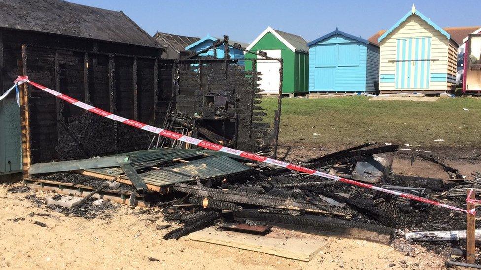 Burnt-out beach huts on Mersea Island.