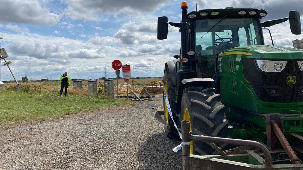 Tractor by a level crossing.