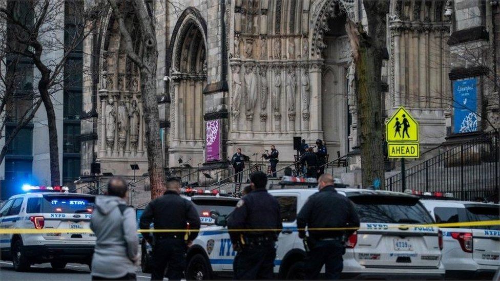 Officers stand outside the Cathedral of St John the Divine in Manhattan after a gunman opened fire