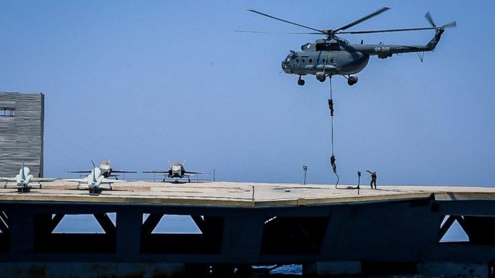 Iranian soldiers jump on the mock carrier