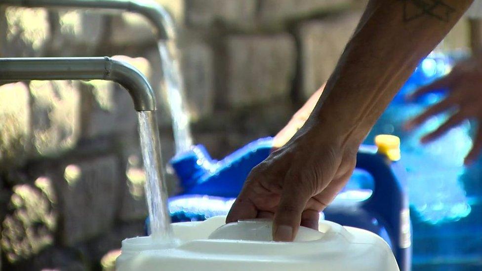 People fill bottles with tap water