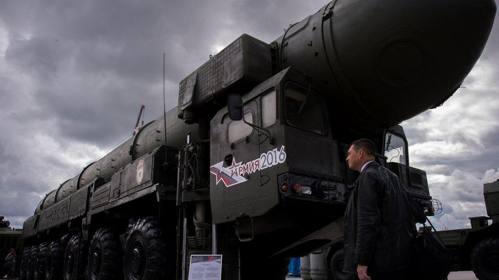 A man looks at a Russian Topol intercontinental ballistic missile launcher