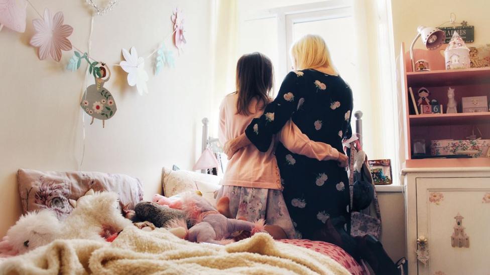 Tracy and her daughter look out of the window