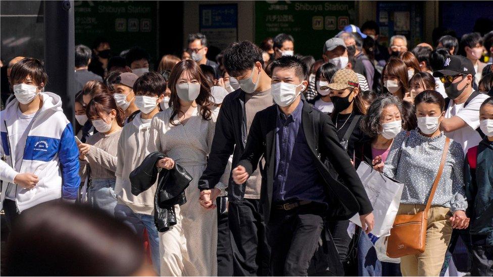 People wearing protective masks walk at a crosswalk at Shibuya In Tokyo, Japan, 18 April 2021.