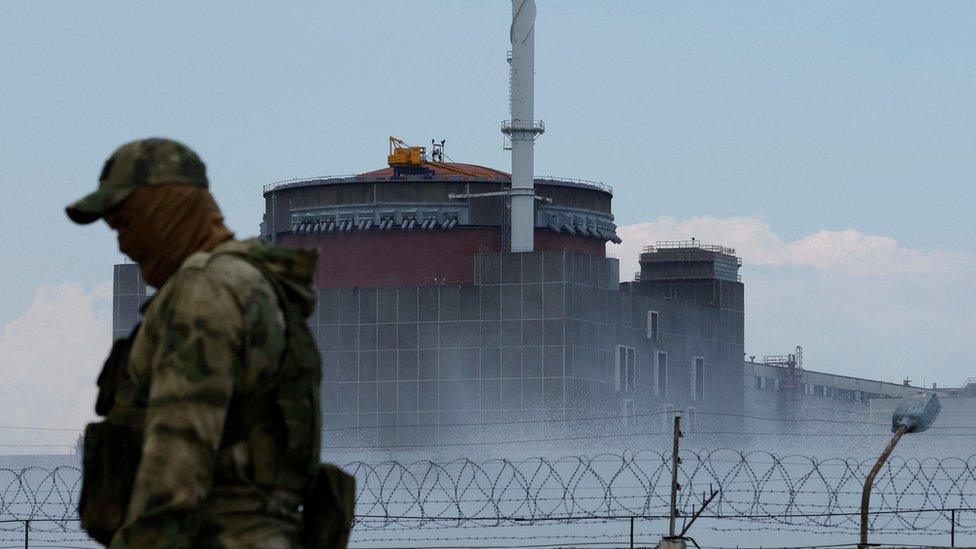 A Russian soldier in front of the Zaporizhzhia Nuclear Power Plant