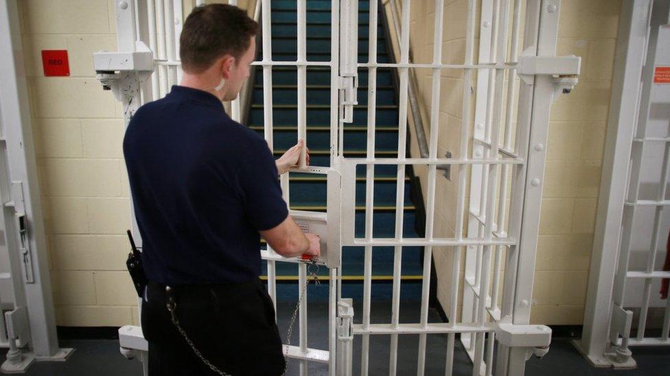 Prison officer locking a gate