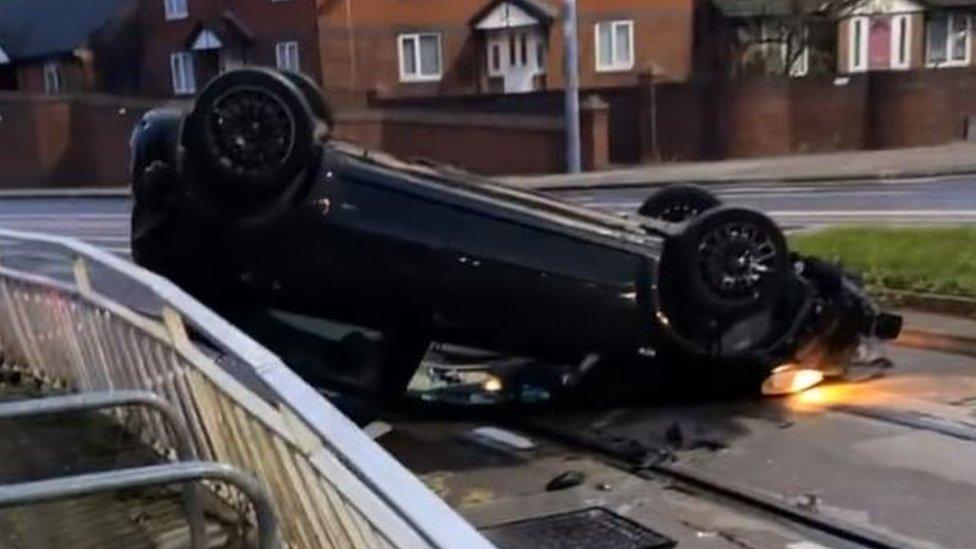 An overturned car on tram tracks in City Road