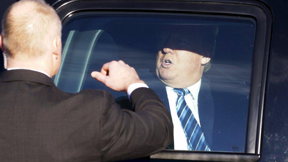 U.S. Republican presidential candidate Donald Trump prepares to leave his vehicle with a U.S. Secret Service agent preparing to open the door before Trump greets supporters at a polling place for the presidential primary in Manchester, New Hampshire February 9, 2016.