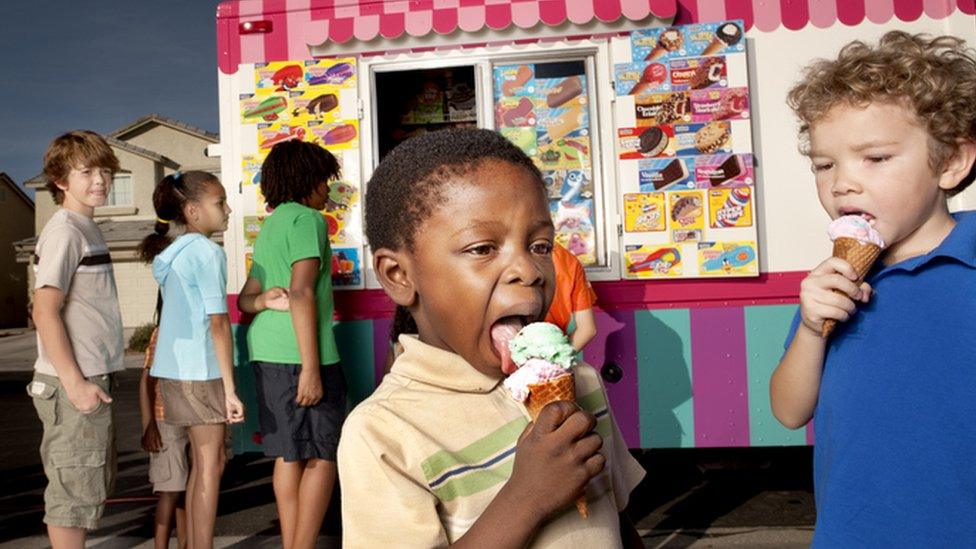 two boys eating ice cream in front of a van