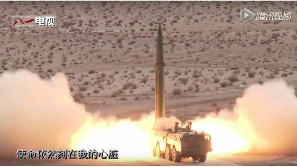 Large missile is launched from a mobile rocket launcher, parked in scrubland