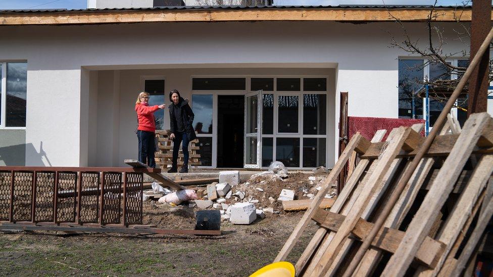 Ludmila with Sarah outside her new home