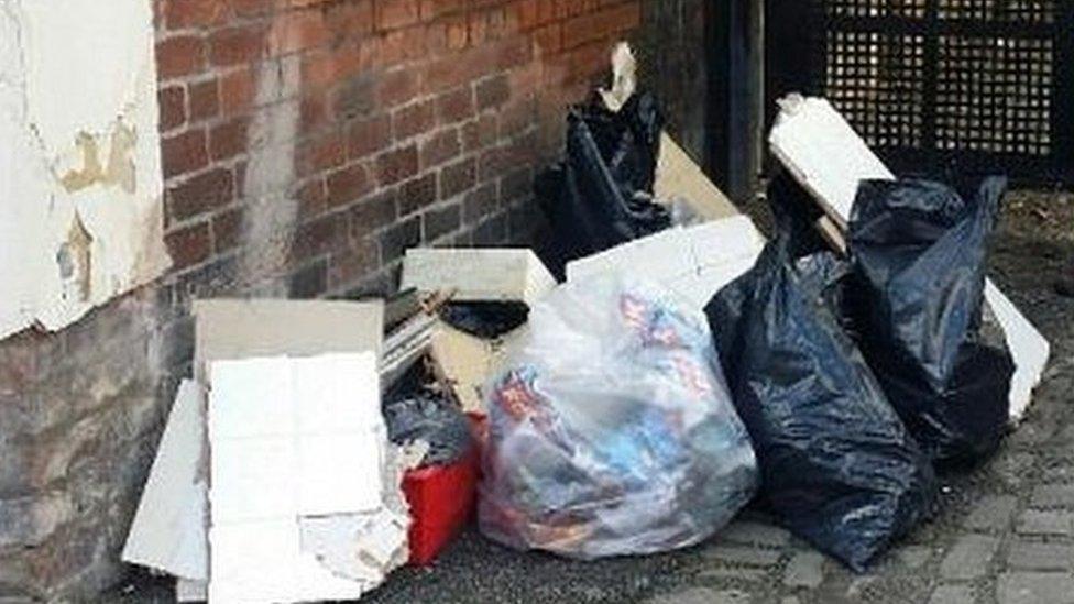 Litter-picker with discarded waste in alley