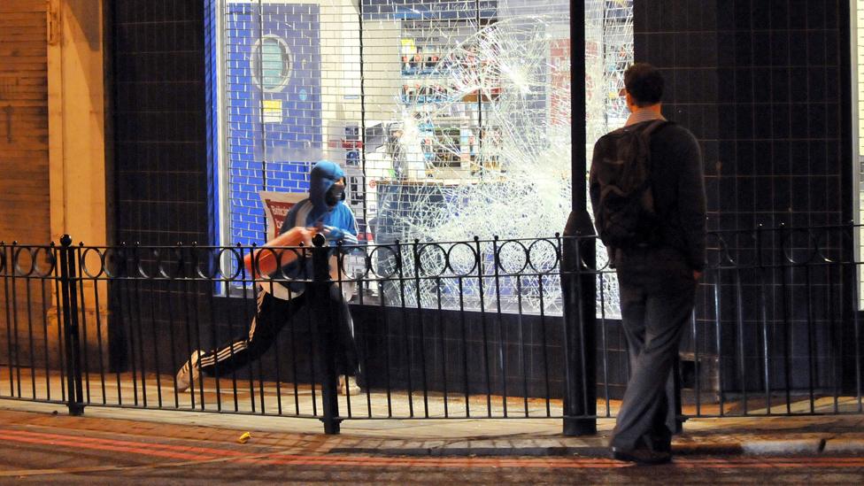 Rioter smashes Carphone Warehouse window with fire extinguisher