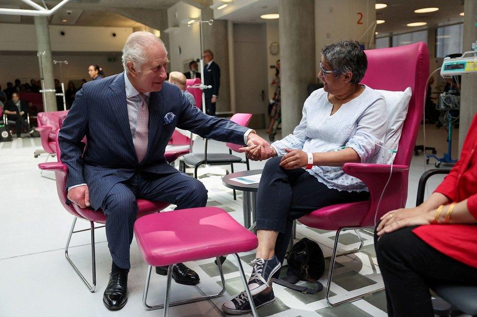 Charles holds hands with cancer patient Asha Millan