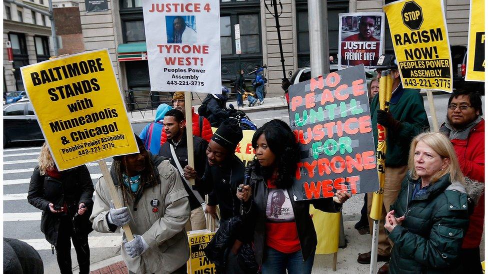 BALTIMORE, MD - NOVEMBER 30: Protestors hold up signs in front of the courthouse where jury selection began in the trial of William Porter, one of six Baltimore city police officers charged in connection to the death of Freddie Gray on November 30, 2015 in Baltimore, Maryland. Porter is the first to go to trial in the death of Gray who died from an injury incurred in the back of a police transport van on April 19 (