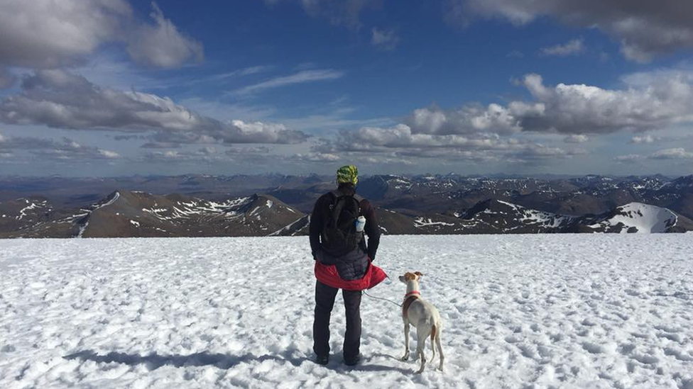 Chris Lewis and Jet in the snow overlooking the mountains