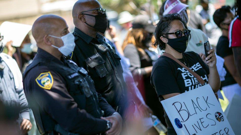 Members of the Richmond police department join protesters for a rally at Nicholl Park in Richmond, California in early June