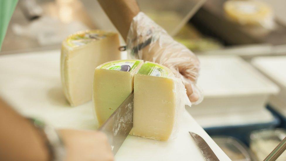 A block of cheese being sliced