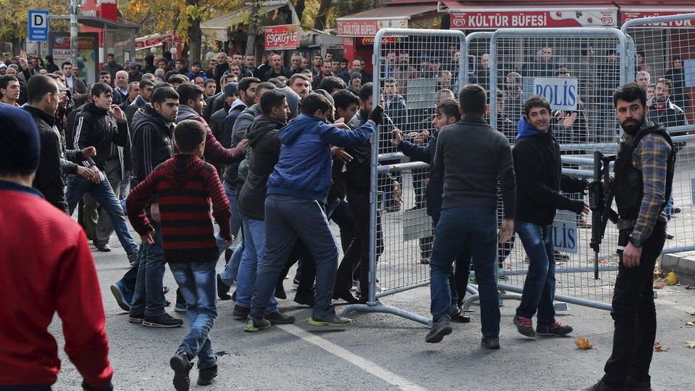 Demonstrators remove security barriers during a protest against the curfew in Sur district, in the south-eastern city of Diyarbakir