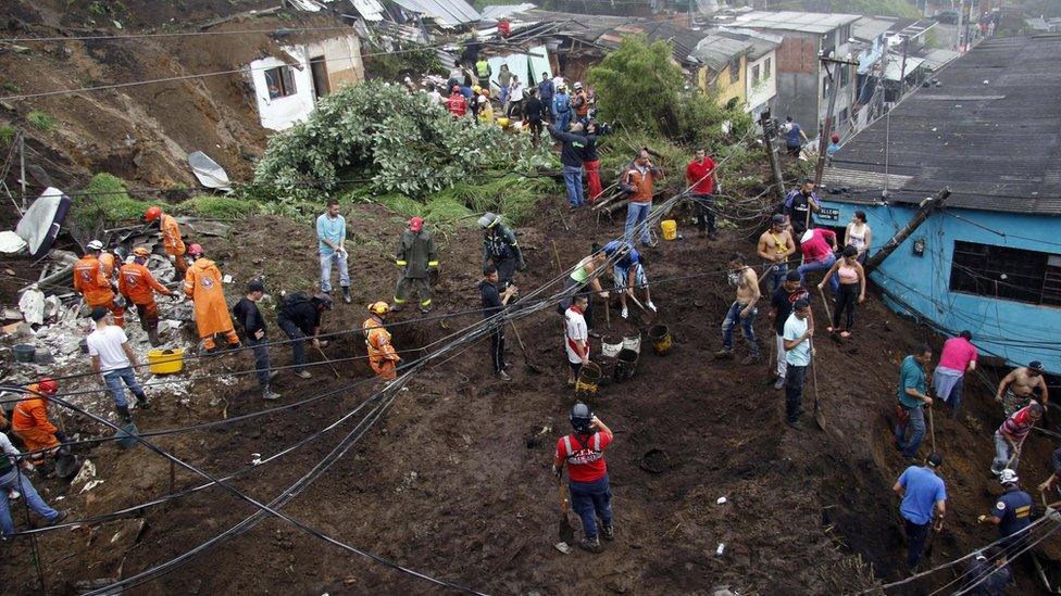 Rescue workers survey an area where a landslide destroyed several homes in Manizales