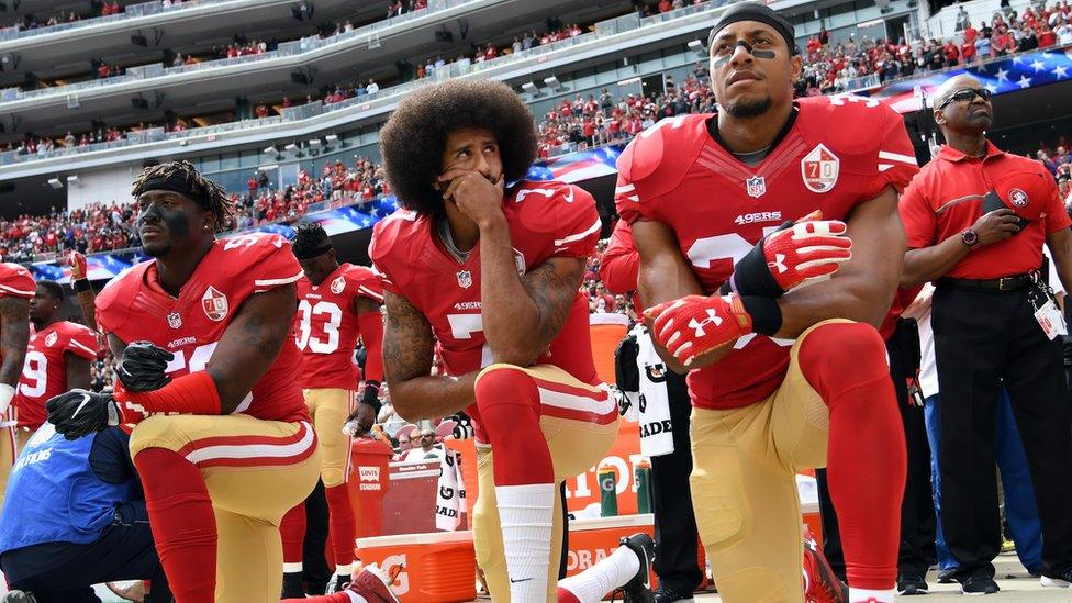 Colin Kaepernick (c) kneeling during the anthem before a game against the Dallas Cowboys