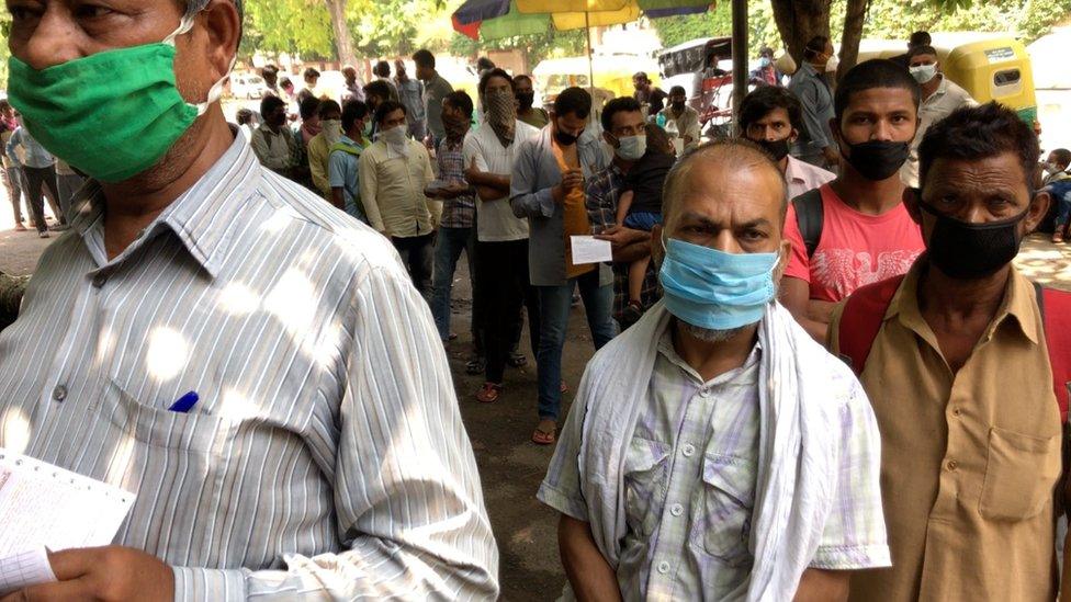 Passengers waiting outside the train station in Delhi