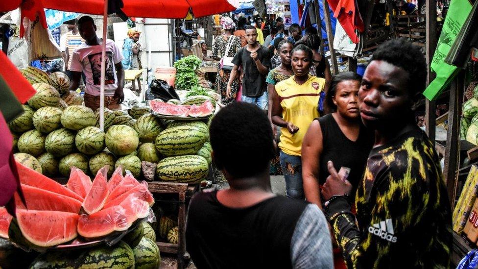 People walk at a market without adhering to the rules of social distancing despite the confirmed Covid-19 coronavirus cases in Dar es Salaam, Tanzania, on April 15, 2020.