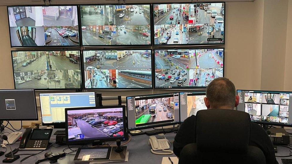 CCTV control room in Bridgwater showing multiple screens with a man in the foreground watching them