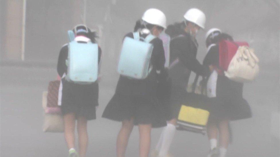 schoolgirls wearing helmets and face masks