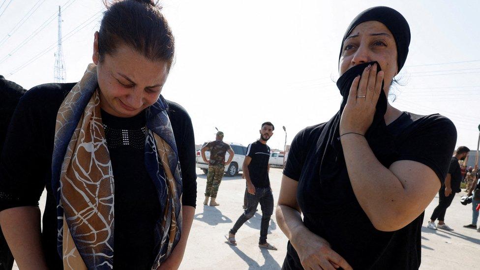 People react following a fatal fire at a wedding celebration, in Qaraqosh, northern Iraq