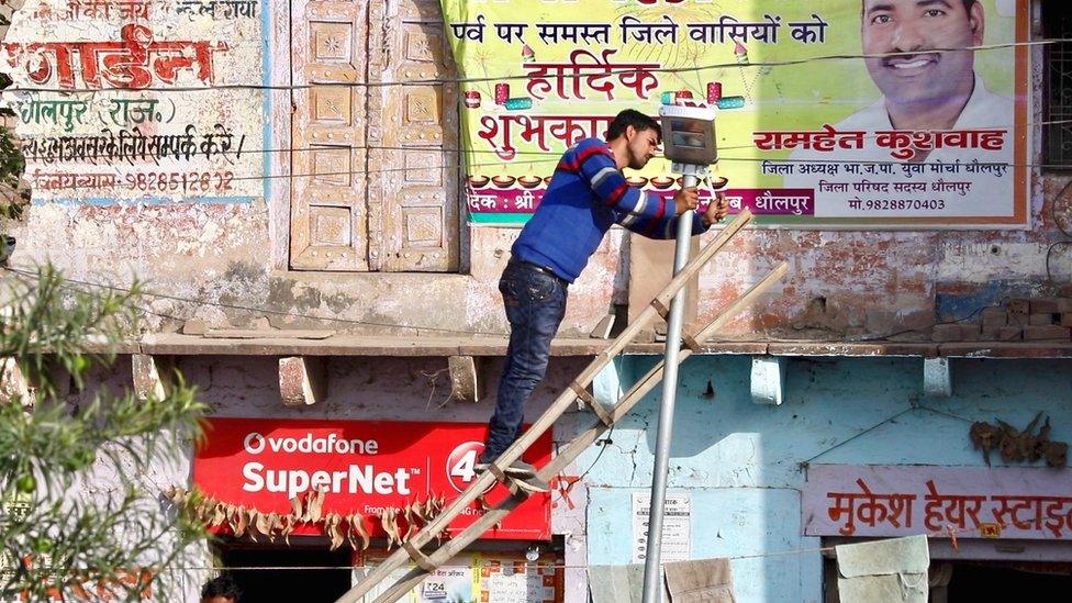 Solar powered street light being installed in a rural village in Rajasthan