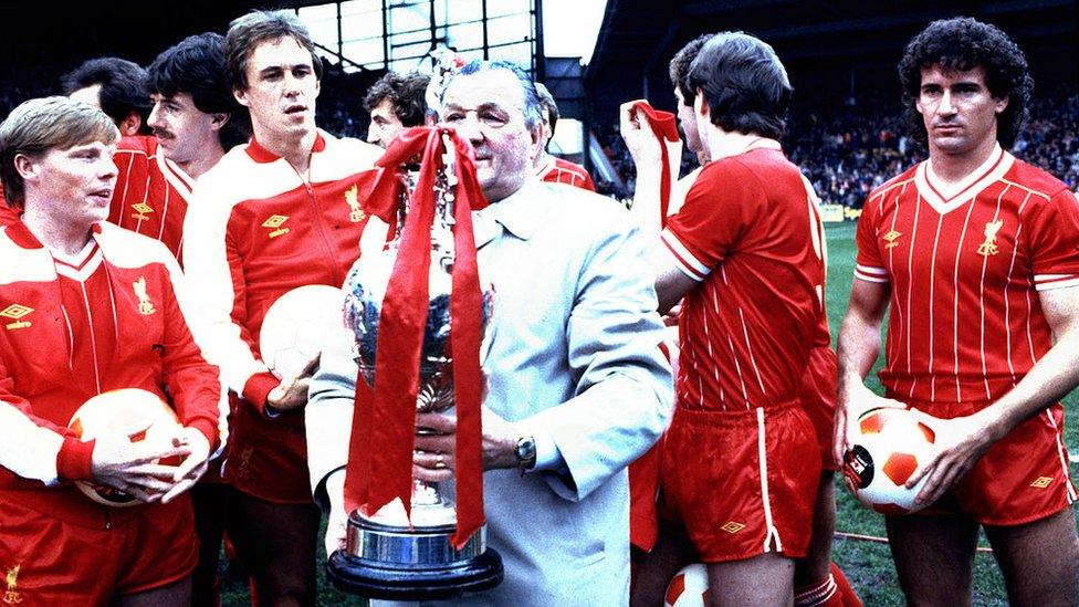 Bob Paisley poses with the winning First Division League Championship trophy in his last season in charge of the club with his players, including Sammy Lee (far L) Phil Neal and Craig Johnson (far R) after the First Division match between Liverpool and Aston Villa held on May 7, 1983 at Anfield