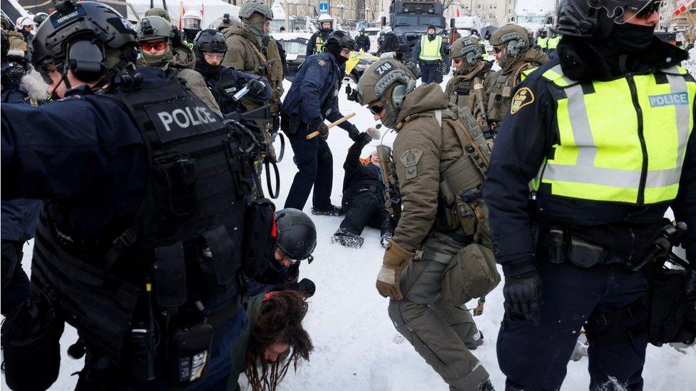 Police detain a protester in Ottawa on Saturday